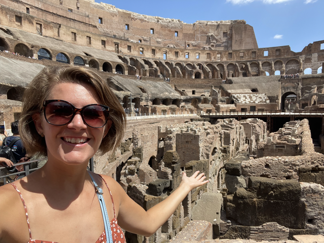 Excitedly pointing to the middle of the ampitheatre from inside the Colosseum in Rome, Italy