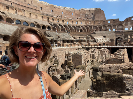 Excitedly pointing to the middle of the ampitheatre from inside the Colosseum in Rome, Italy